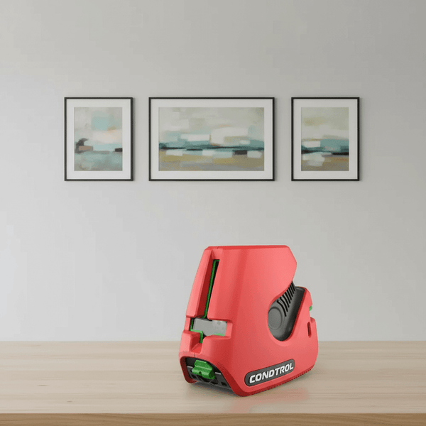 Ist ein Kreuzlinienlaser sinnvoll? - Bild eines roten Kreuzlinienlasers auf einem Tisch mit Wandbildern im Hintergrund.